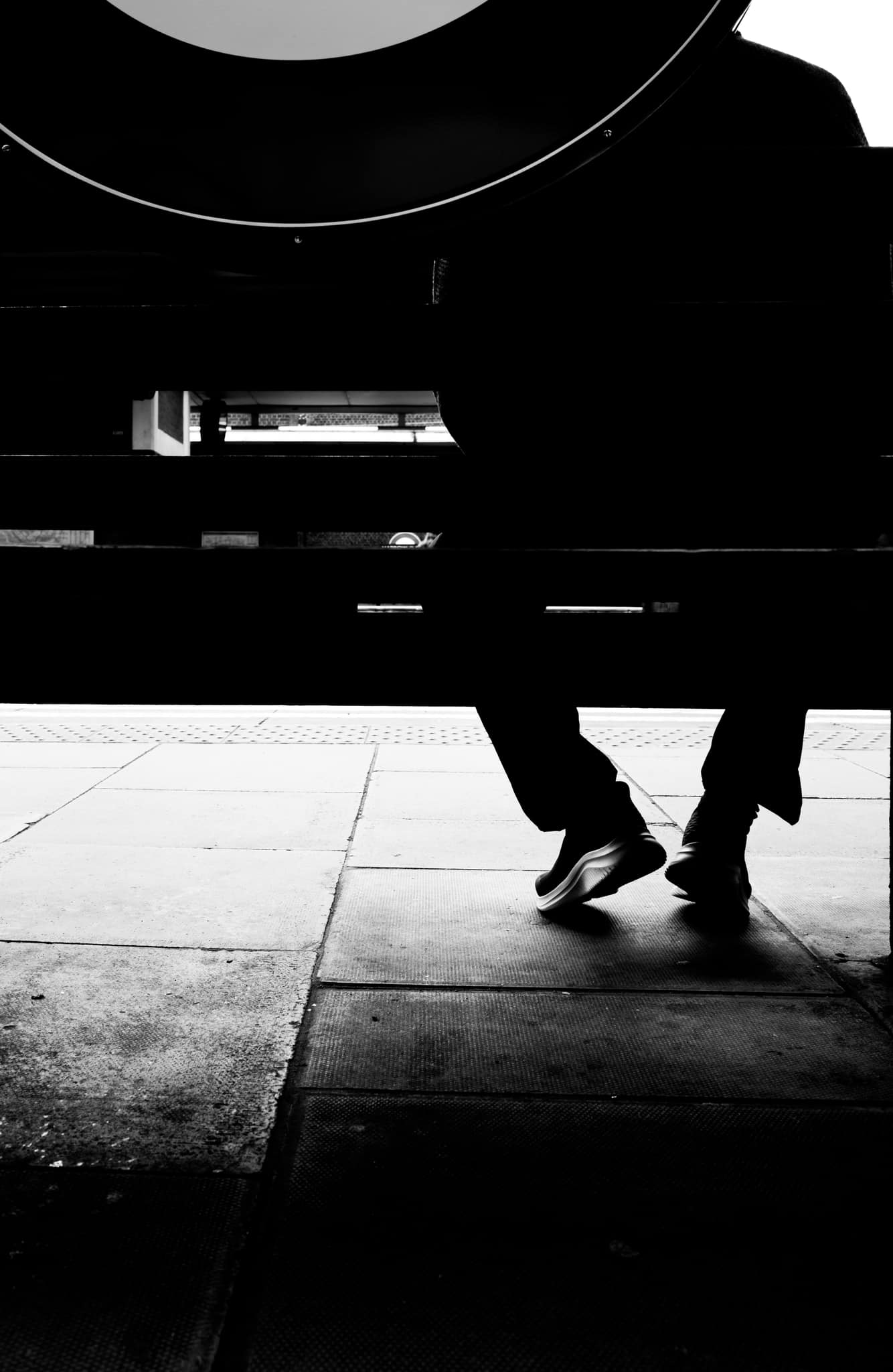 portrait of man sitting on a bench in a London underground station waiting for a train 