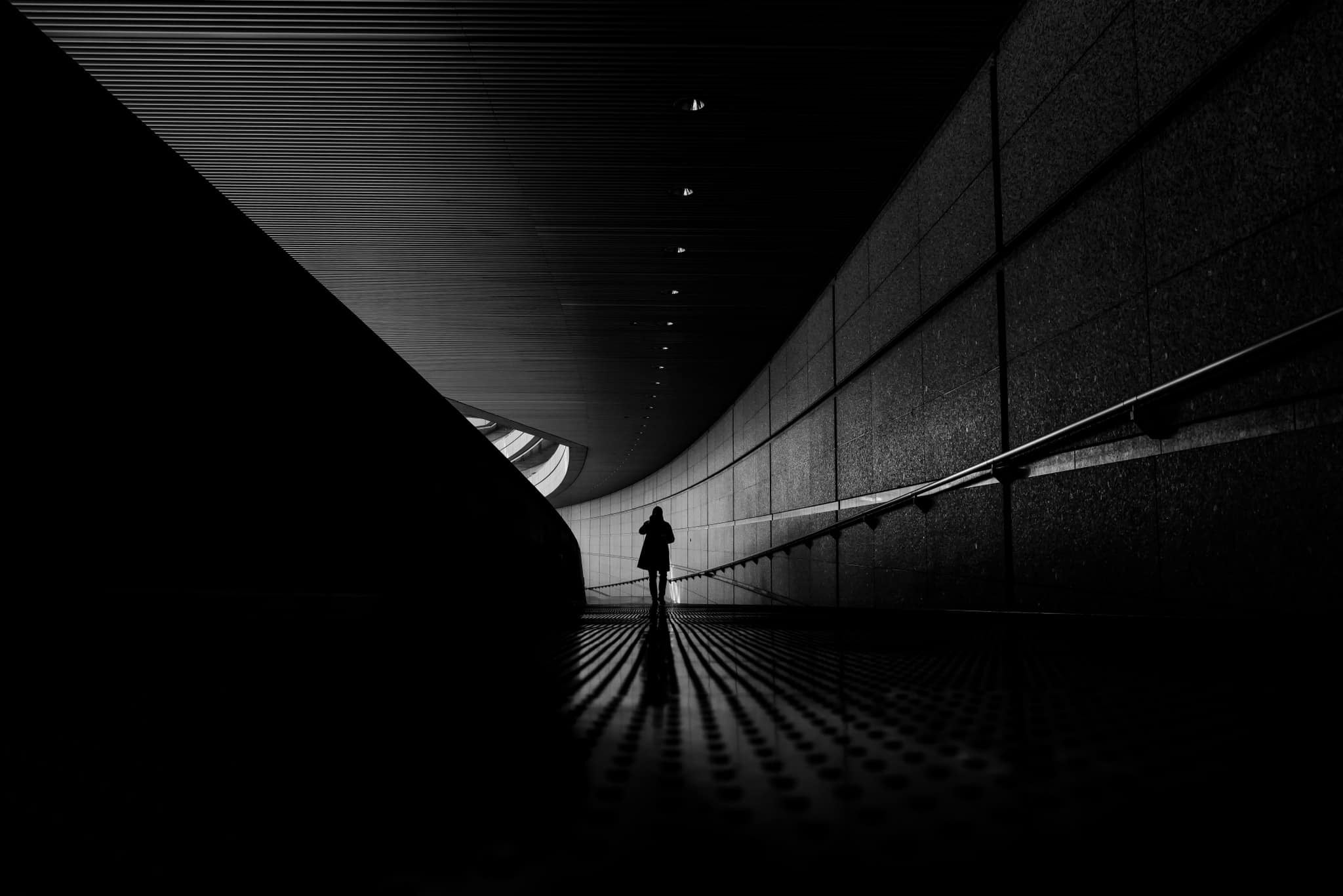 Person walking in London tube station in black and white