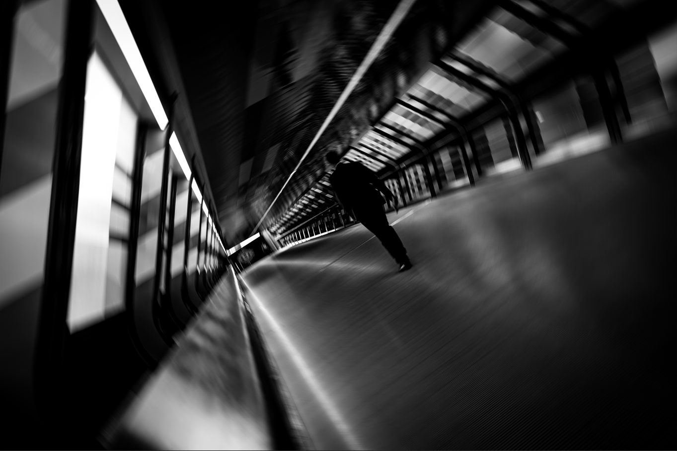 Black and white photo of man in suit walking down hallway