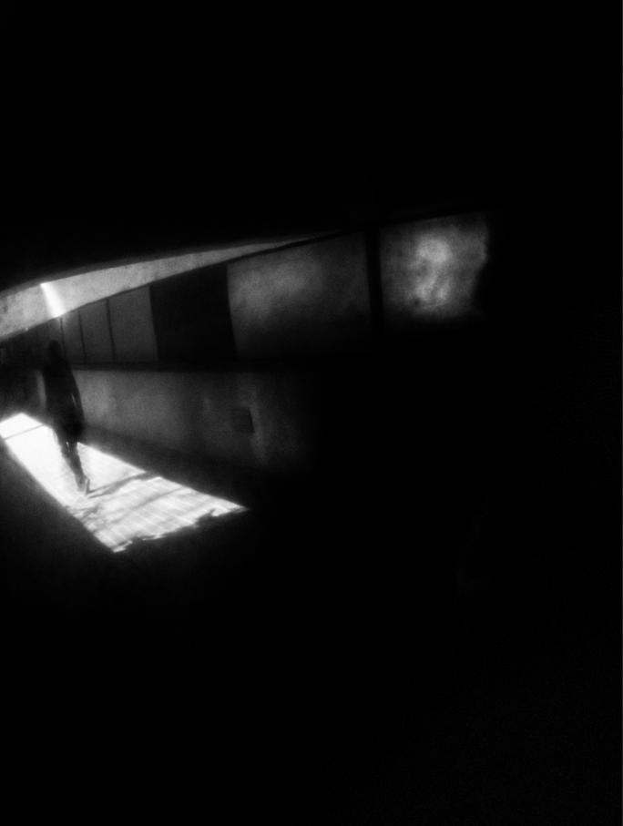 blurred monochrome art of person walking through a tunnel 