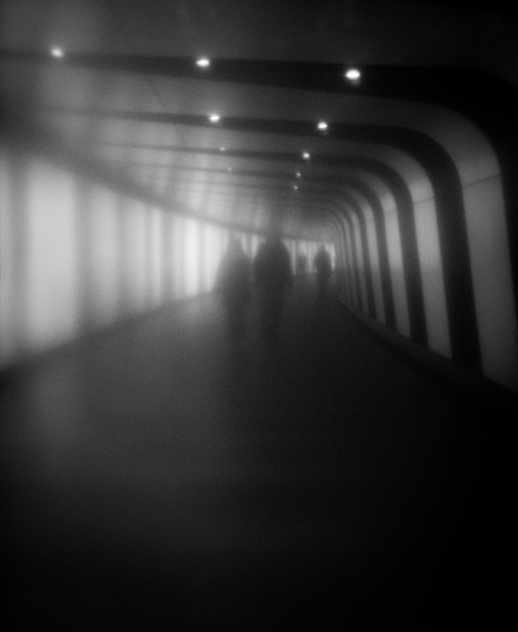 misted photo of people walking through a tunnel on the London underground 