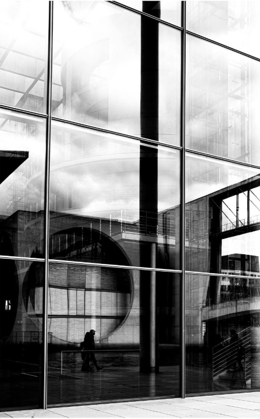 Modern architectural interior with glass walls reflecting the building's structure.