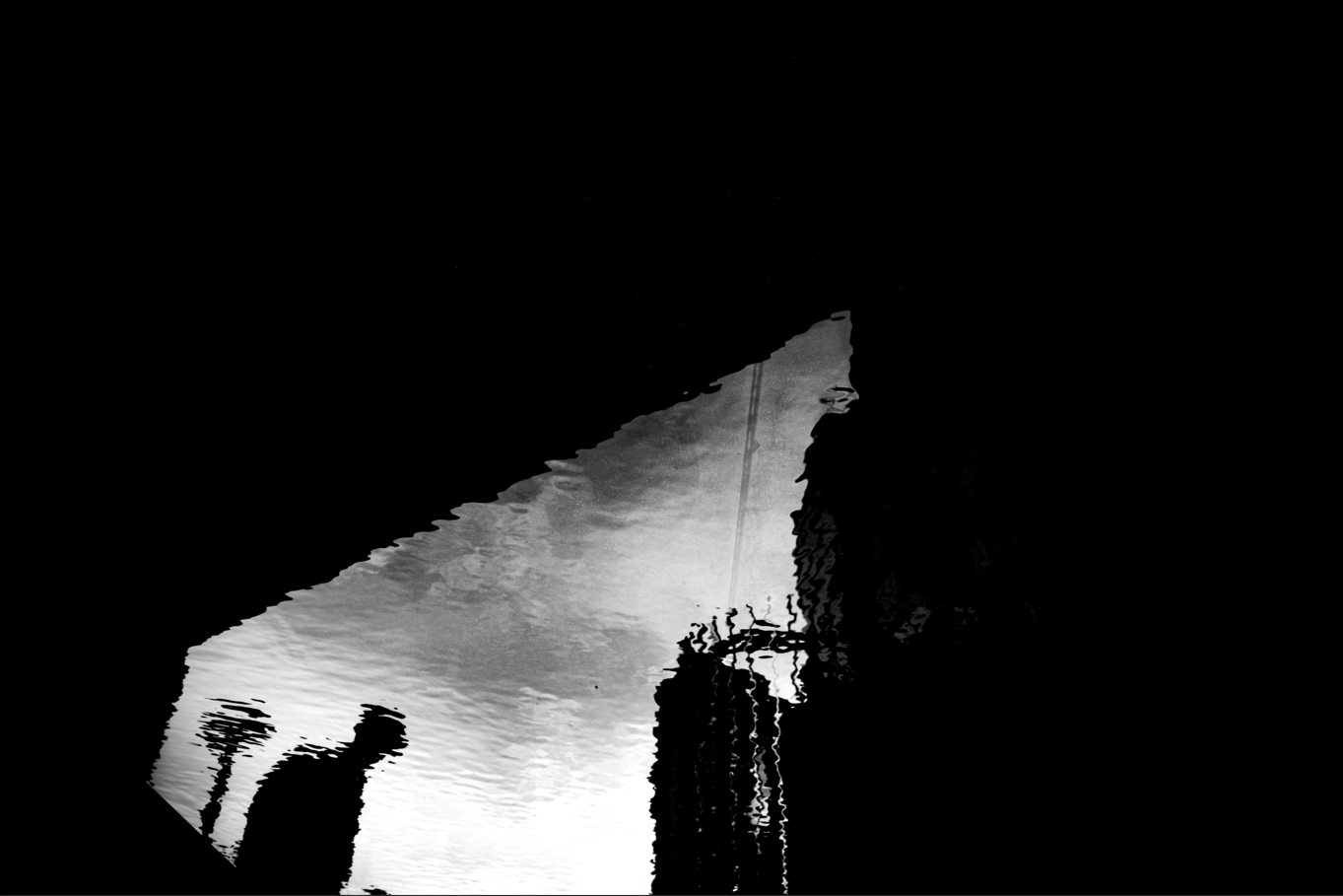 monochrome artwork of man's reflection in a puddle 