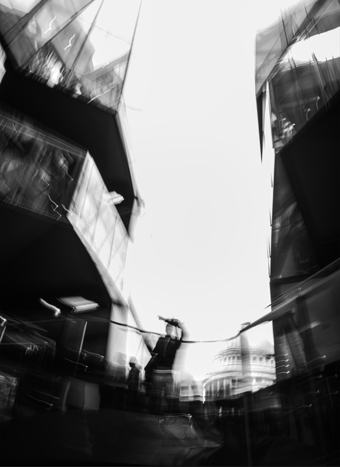 black and white photo of person standing on a bridge 
