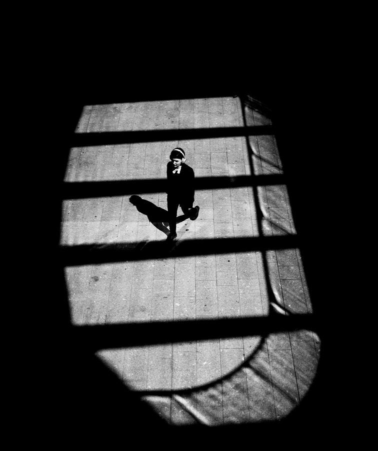 Person walking on a crosswalk with a strong shadow effect
