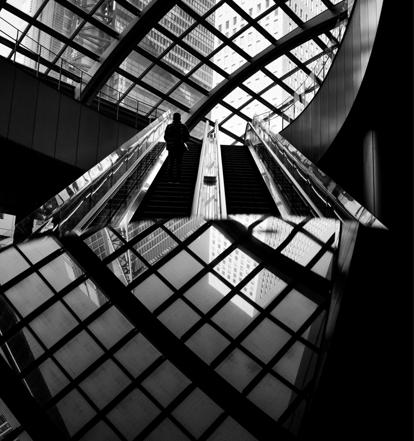 Person on an escalator in a modern building with glass ceiling